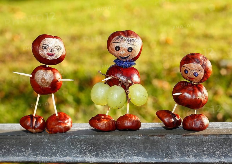 Three chestnut figures with grapes in the evening light
