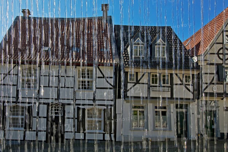 Half-timbered houses behind water from the weavers' well at Tuchmacherplatz