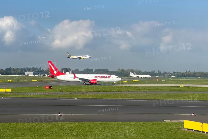 Two aircraft passenger jets jets jets jets in front Corendon Airlines in the back Condor on parallel runway runway during simultaneous takeoff takeoff and landing touchdown at Duesseldorf International Airport