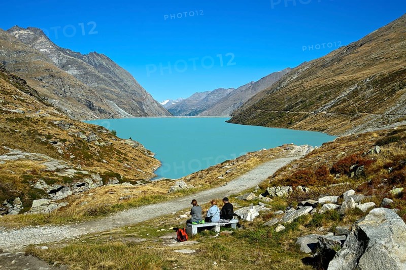 Three hikers resting at the Mattmark reservoir