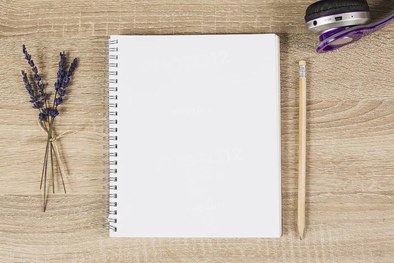 Blank spiral notebook pencil headphone lavender twigs wooden background