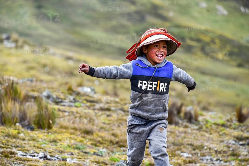 Running boy with traditional hat in the Andes