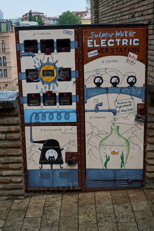 Electricity meters and cable distribution boxes decorated with graffiti on a street in the old town