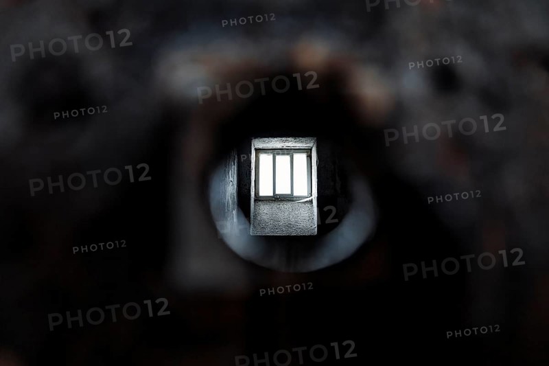 View through peephole into dark prison cell