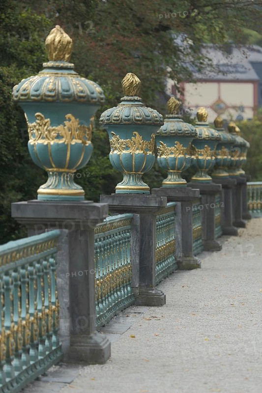 A row of golden lidded vases on a balustrade in the castle garden