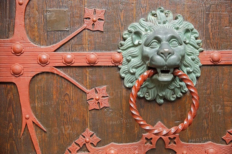 Fittings with lion's head and door knocker ring on the church door of St. Valentinus and Dionysius