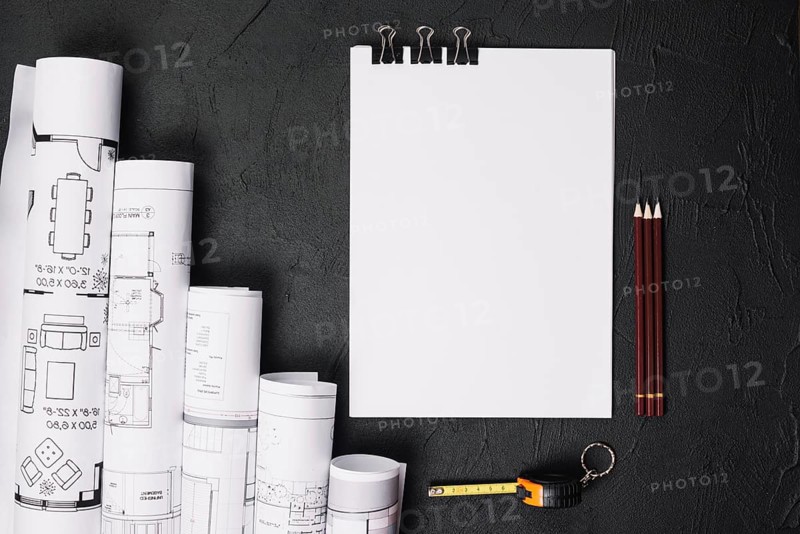 Blank paper with blueprints on table