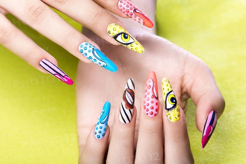Long beautiful manicure in pop-art style on female fingers. Nails design. Close-up