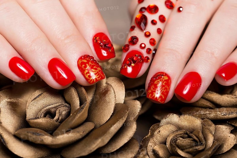 Shot beautiful manicure with rhinestones on female fingers. Nails design. Close-up. Picture taken in the studio