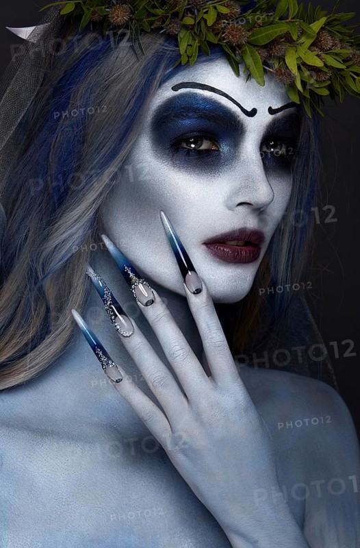 Portrait of a horrible scary Corpse Bride in wreath with dead flowers