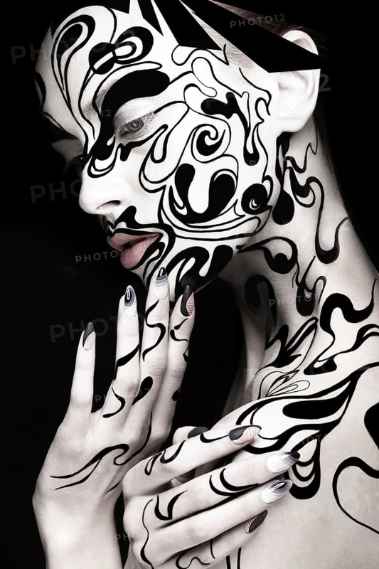Beautiful girl with art black and white makeup and nails. Creative beauty face. Photo taken in the studio