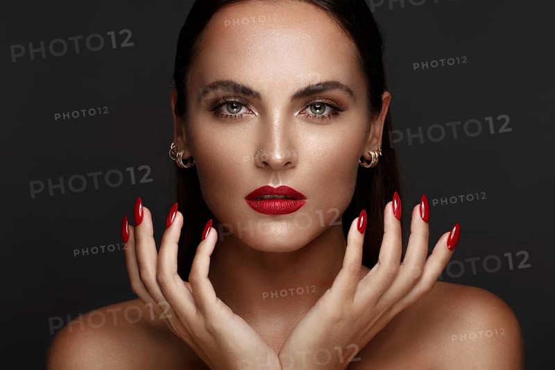 Beautiful girl with a classic make up and multi-colored nails. Manicure design. Beauty face. Photo taken in the studio