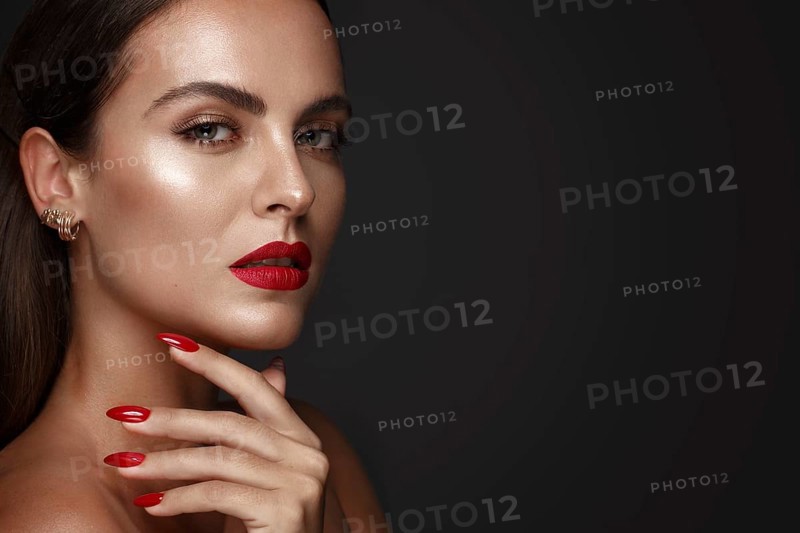Beautiful girl with a classic make up and multi-colored nails. Manicure design. Beauty face. Photo taken in the studio