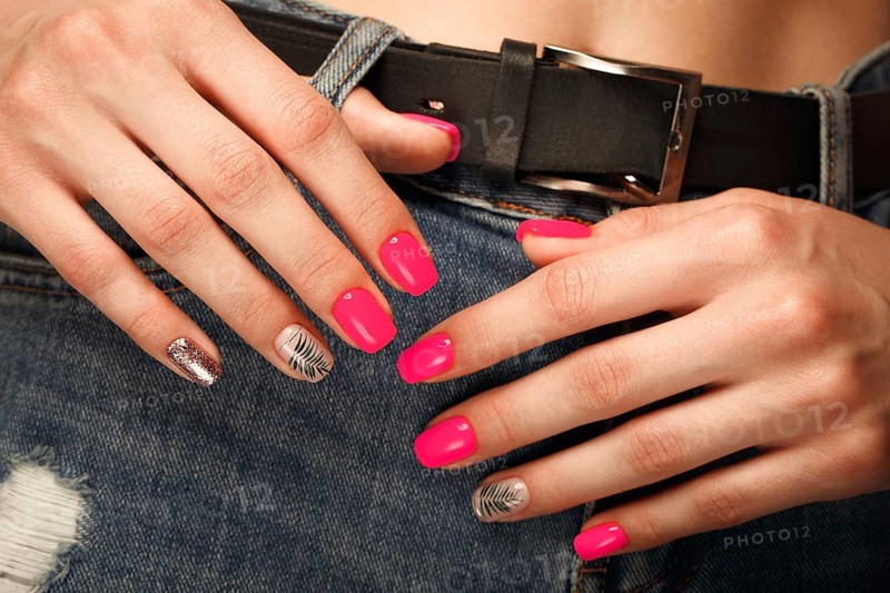 Bright neon manicure on female hands on the background of jeans. Nail design. Beauty hands