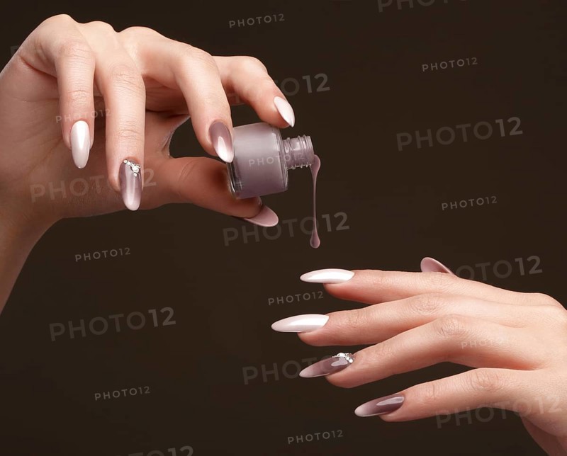 Beautiful classic manicure on female hand with nail polish. Close-up. Picture taken in the studio