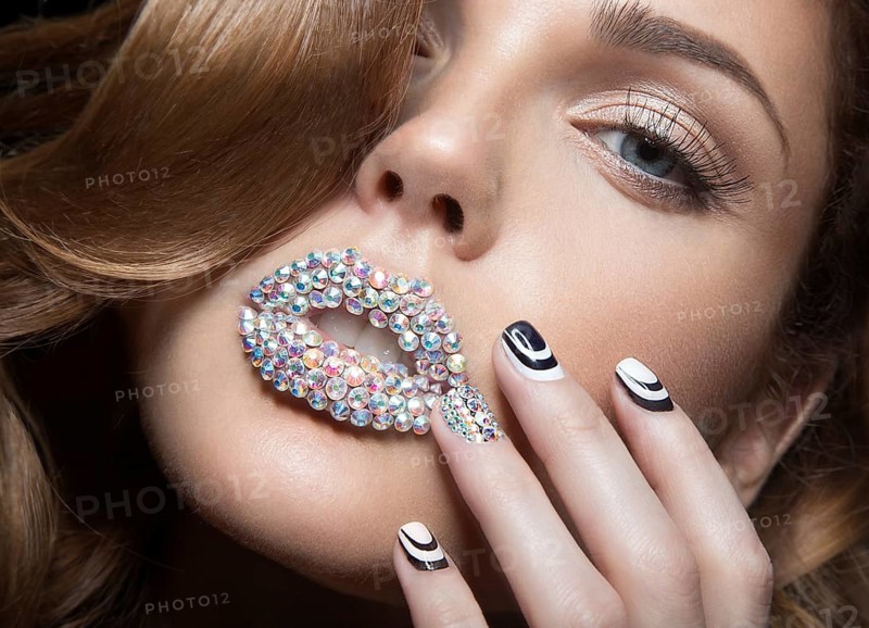 Beautiful girl with bright nails and lips of crystals