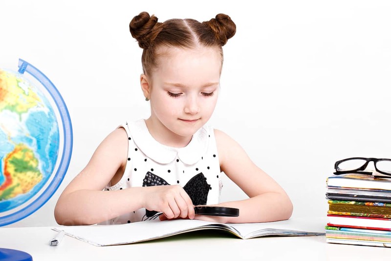 Little girl at the table of a first-grader. Photo taken in the studio