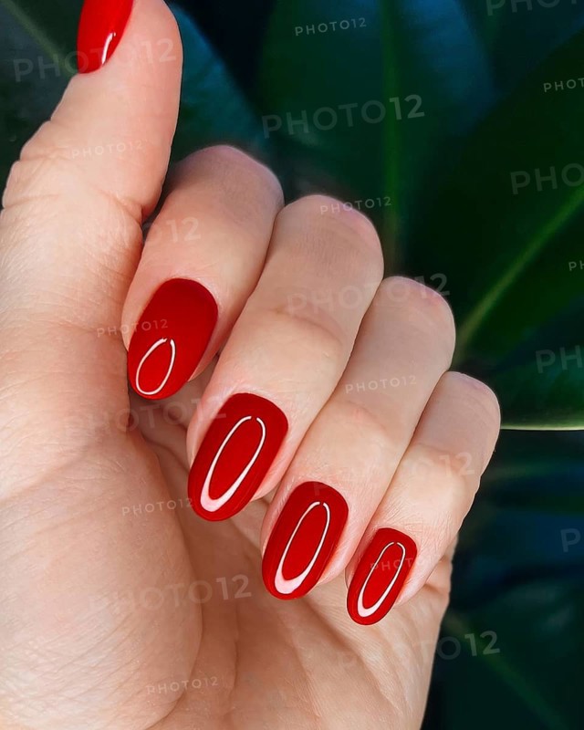Bright festive red manicure on female hands. Nails design