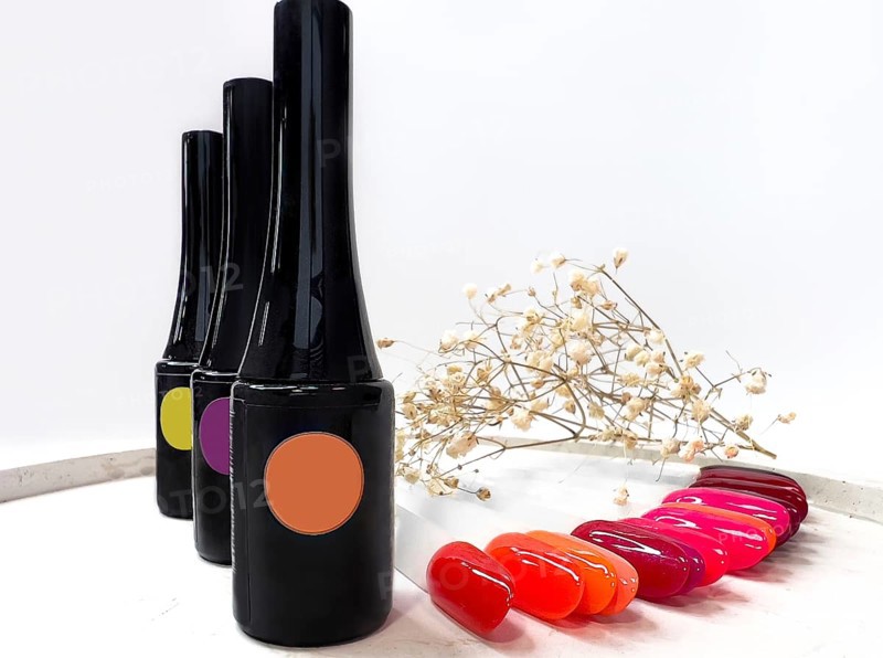 Black bottles of nail polish on a white background with flowers. Manicure design