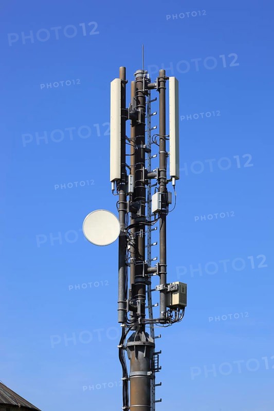Transmission mast with directional radio antenna and antennas for mobile phone reception