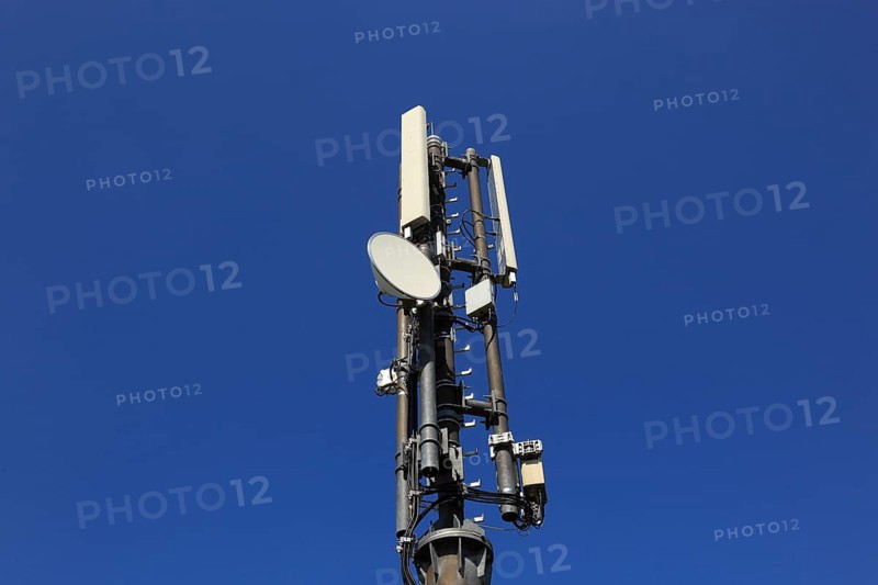 Transmission mast with directional radio antenna and antennas for mobile phone reception