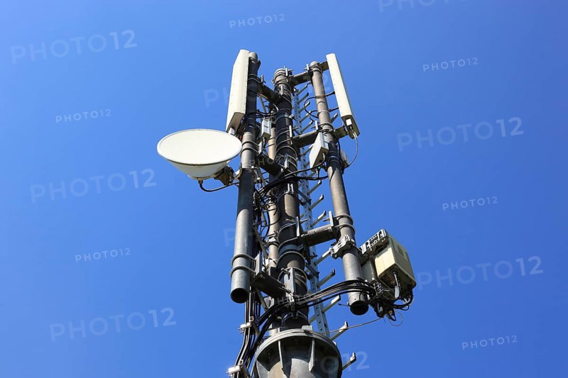 Transmission mast with directional radio antenna and antennas for mobile phone reception