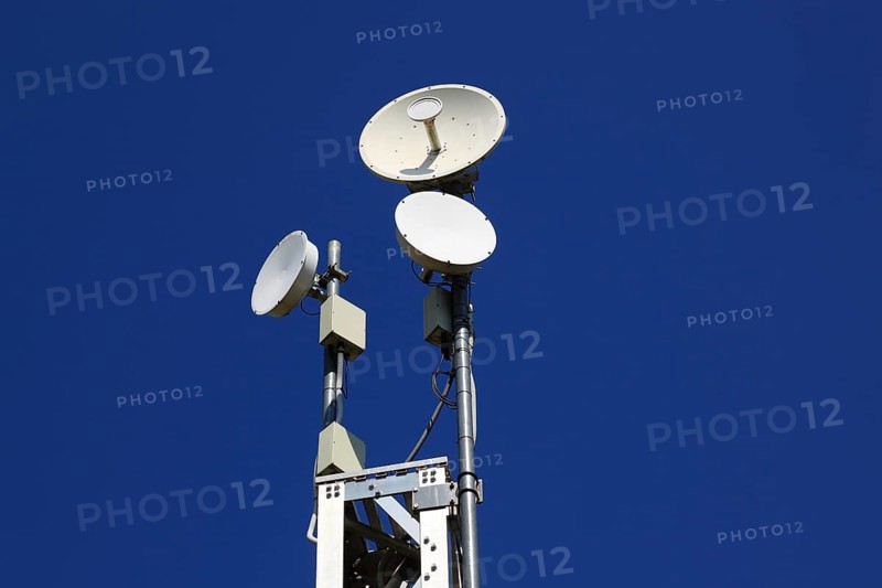 Transmission mast with directional radio antenna and antennas for mobile phone reception