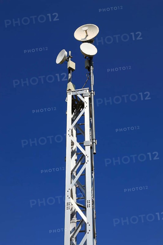 Transmission mast with directional radio antenna and antennas for mobile phone reception