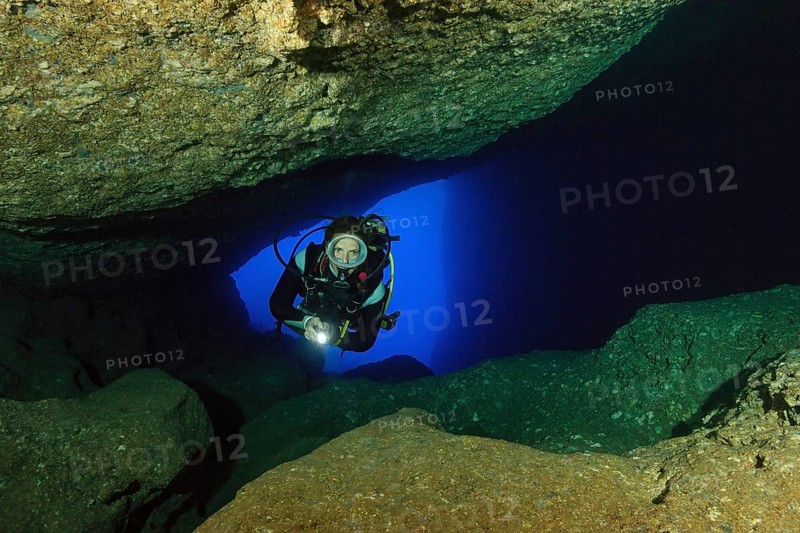 Diver sport diver swims in illuminated cave underwater cave