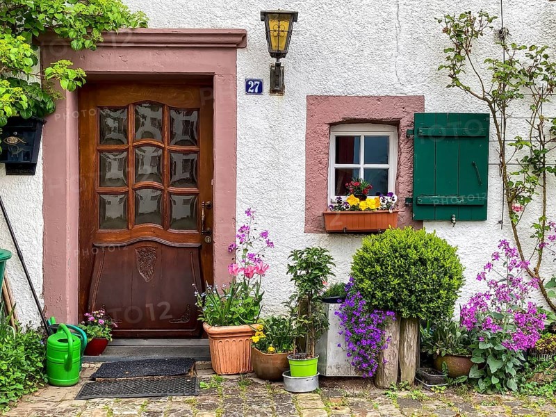 House entrance decorated with flowers and plants in old village Burgdorf Burgbering from 13th century of today destroyed castle Kronenburg
