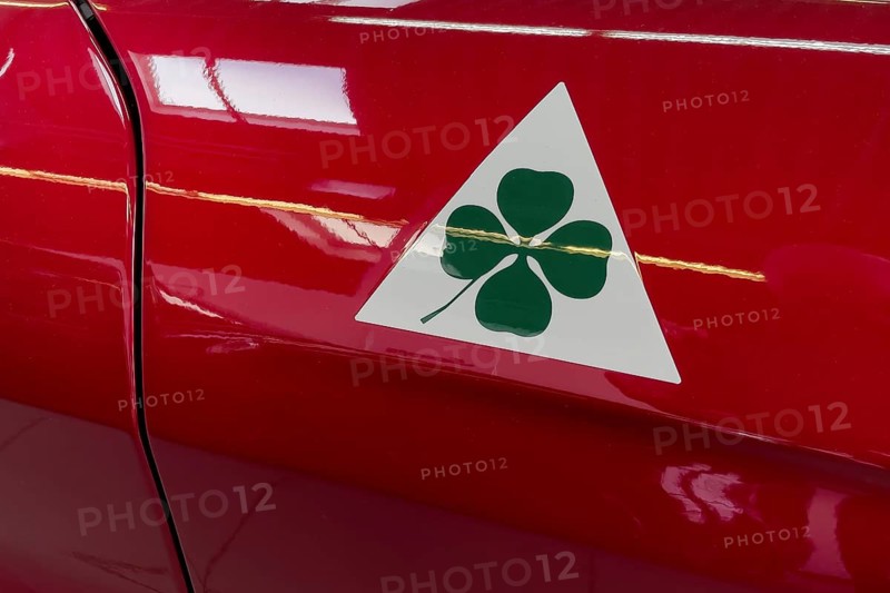 Historic modern signet logo marking Alfa Romeo Quadrifoglio green four-leaf clover on white triangle for sporty cars racing cars