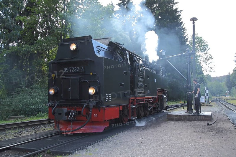 Steam locomotive refuelling water at the water crane