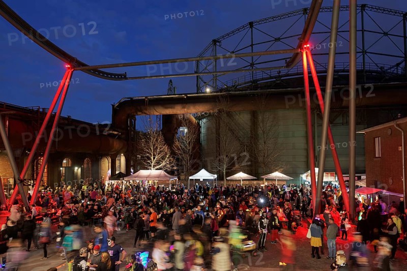 Crowds of people against a nocturnal industrial backdrop