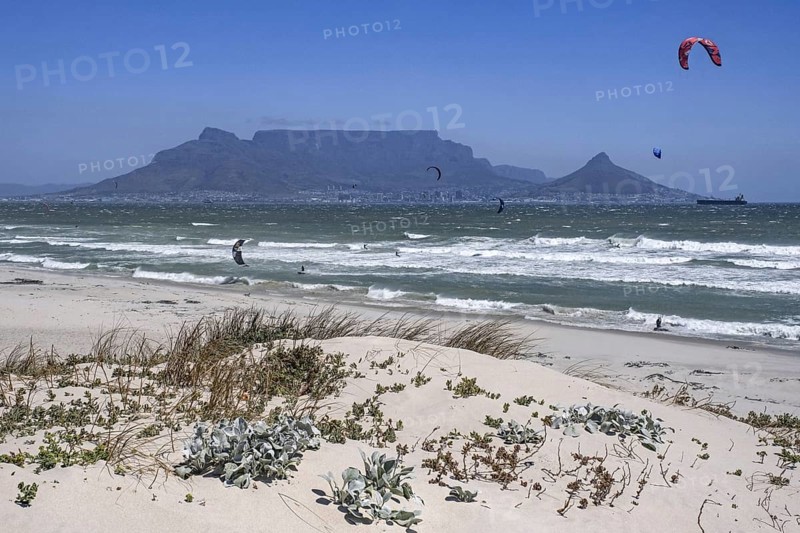 Table Mountain and kitesurfers at Bloubergstrand along the Atlantic Ocean shores of Table Bay near Cape Town