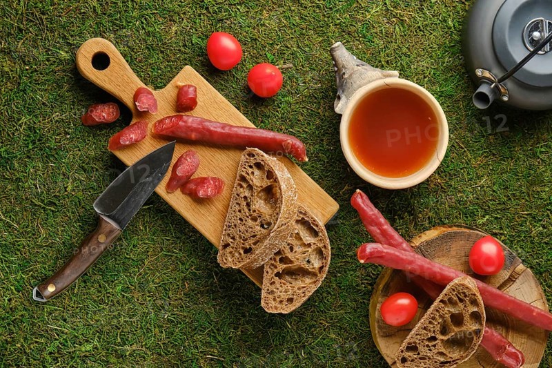 Top view of snack in the woods with dried thin sausage