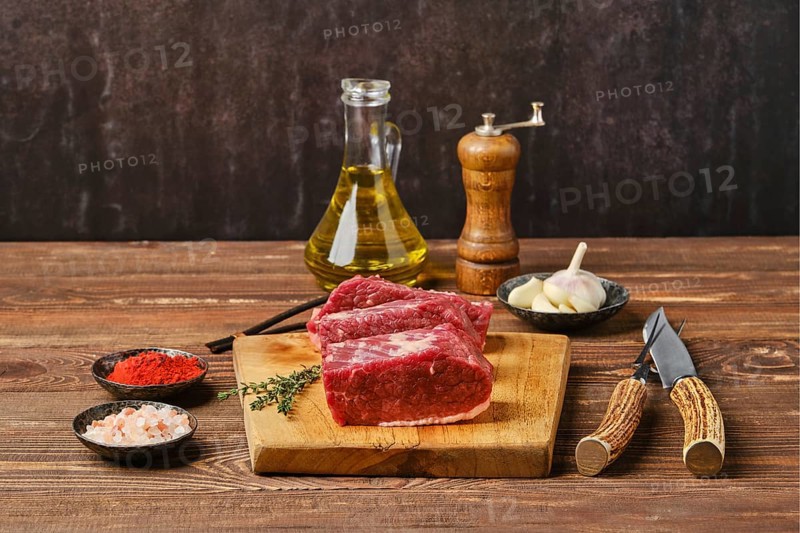 Raw beef brisket flat steak on wooden tabletop ready for cooking