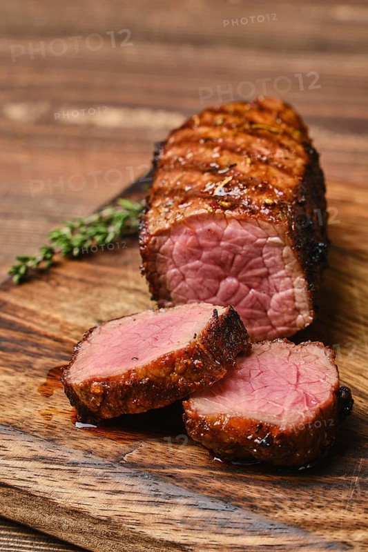 Closeup view of juicy roasted beef brisket flat steak on wooden cutting board
