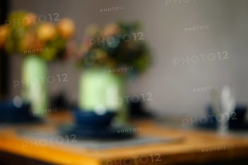 Defocused photo of empty table served for dinner. Abstract bokeh