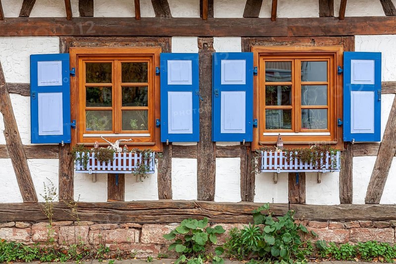 Half-timbered house with mullioned windows and blue shutters