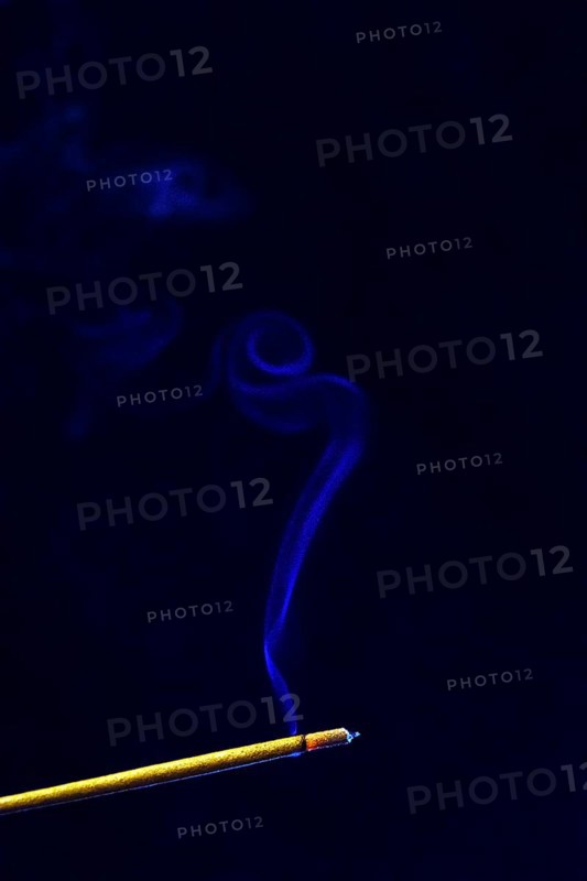 Blue smoke plume from an incense stick
