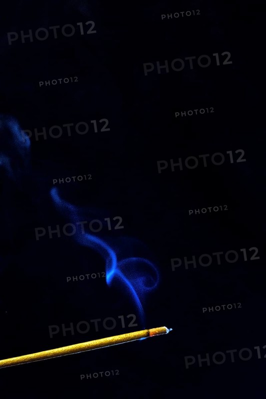 Blue smoke plume from an incense stick