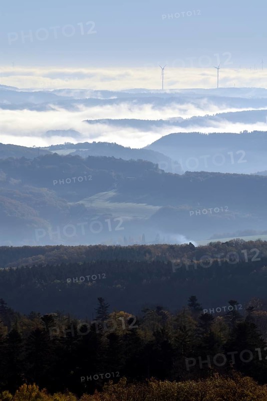 View from Moerschieder Burr mountain in the Hunsrueck-Hochwald National Park over the Naheland and North Palatinate mountains on a misty autumn morning