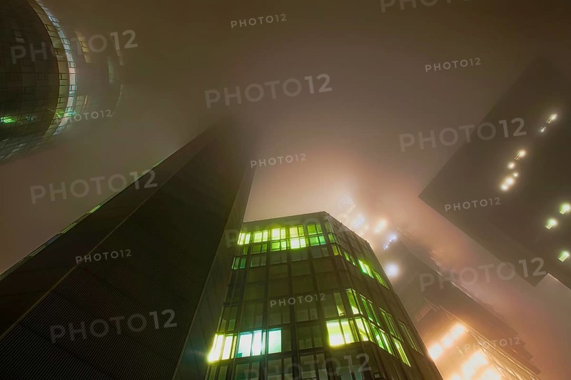 Illuminated skyscrapers in the fog at night