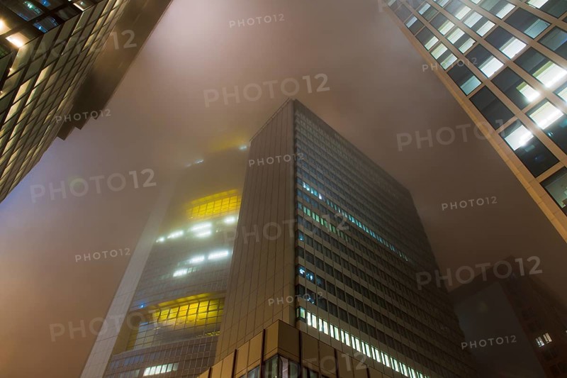 Illuminated skyscrapers in the fog at night