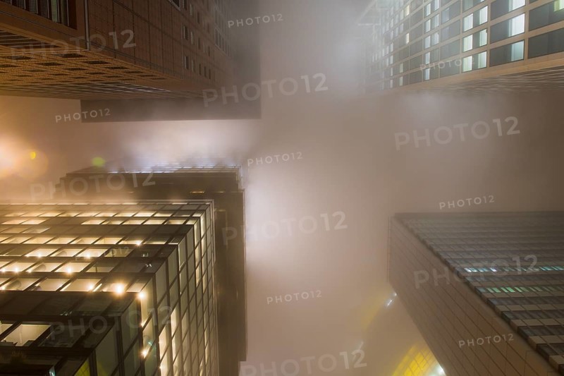 Illuminated skyscrapers in the fog at night
