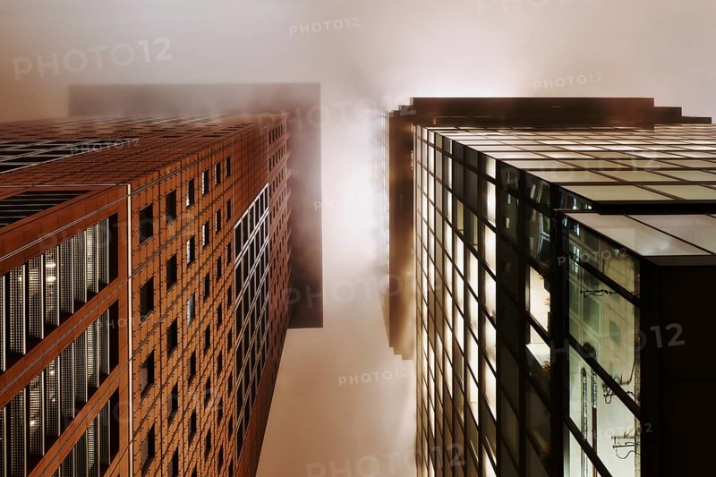 Illuminated skyscrapers in the fog at night
