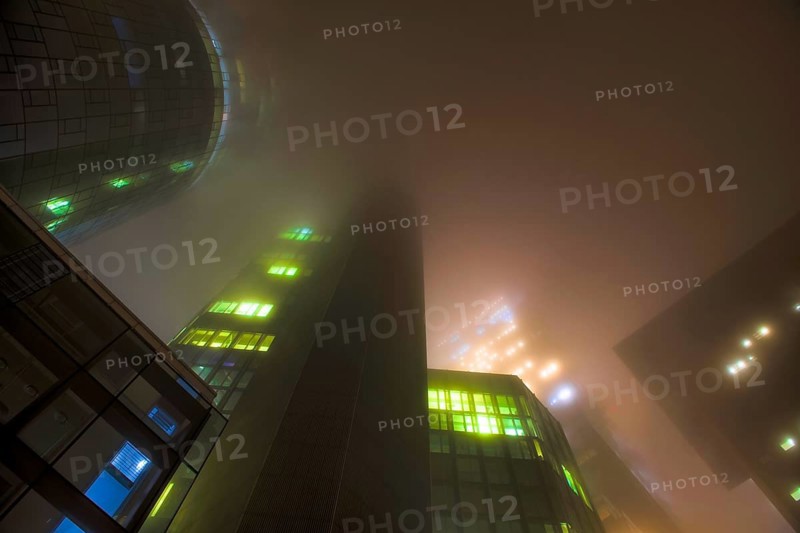 Illuminated skyscrapers in the fog at night