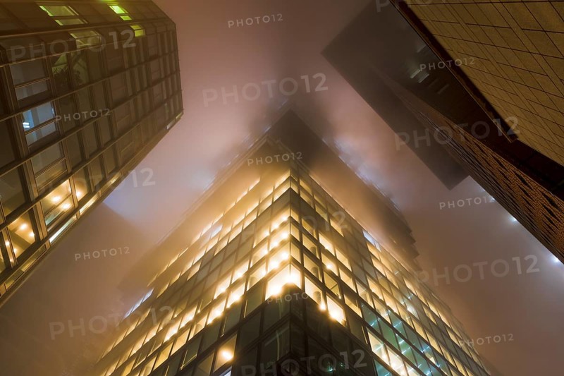 Illuminated skyscrapers in the fog at night