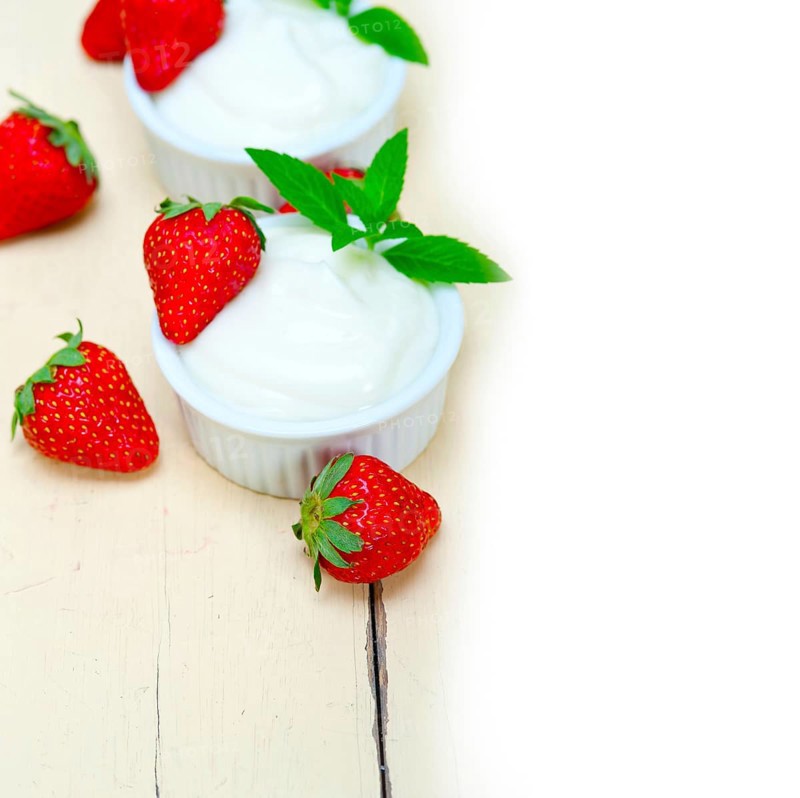 Organic Greek yogurt and strawberry over white rustic wood table