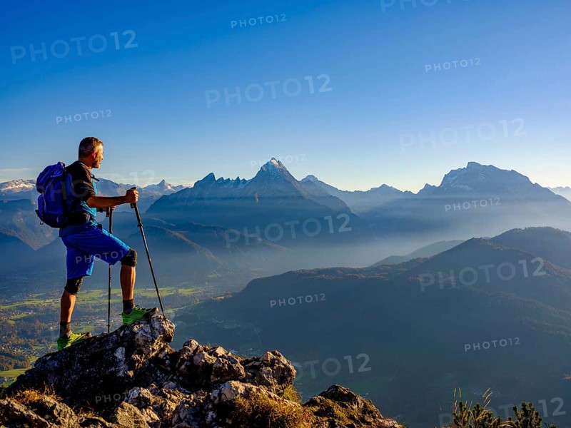 Mountaineer at the summit Rauher Kopf looking at the Berchtesgaden Alps